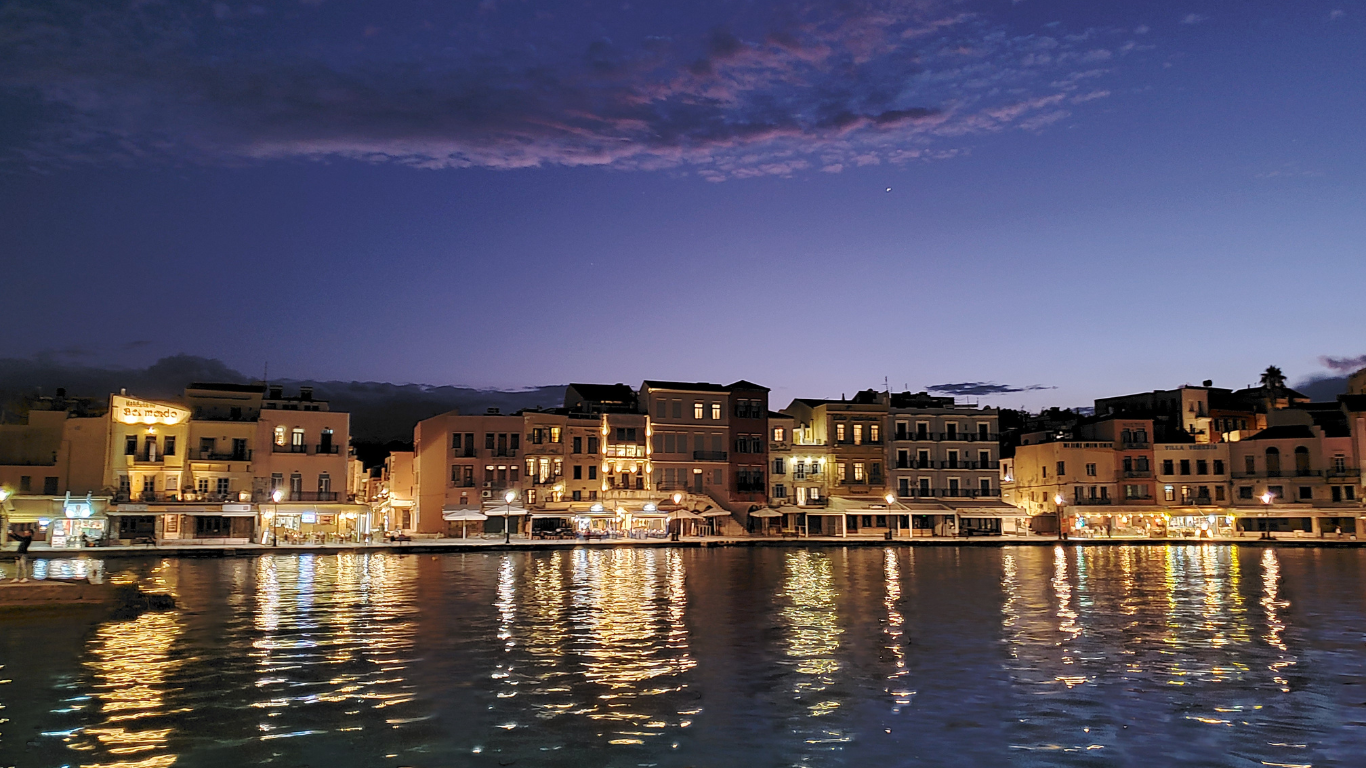 Op een terrasje klinken glazen raki, terwijl de lucht zich vult met de geur van gegrilde aubergine, tijm en zeezout.