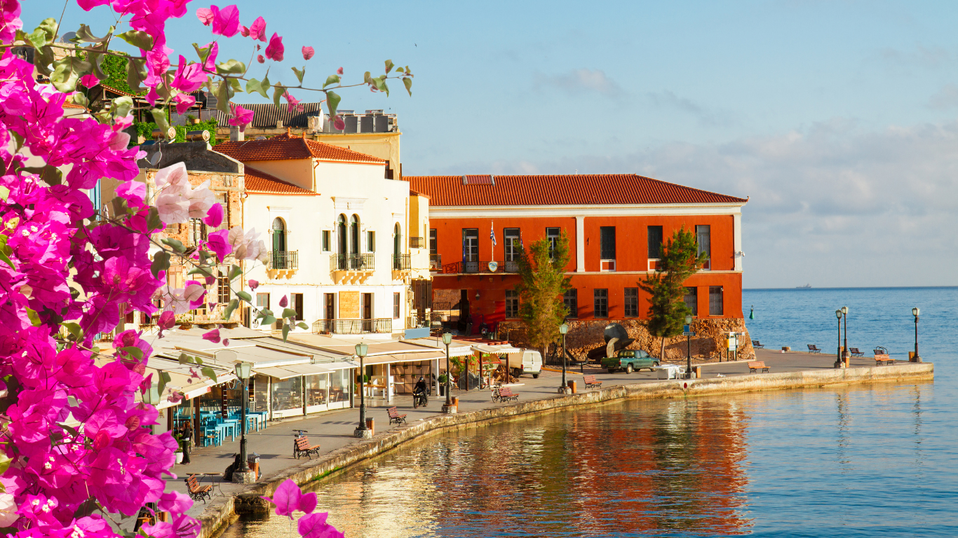 Terrasje aan de Venetiaanse haven van Chania met uitzicht op zee en vuurtoren bij zonsondergang